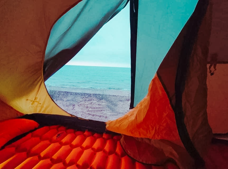 view of the beach from inside my sisters tents on a women backpacker trip