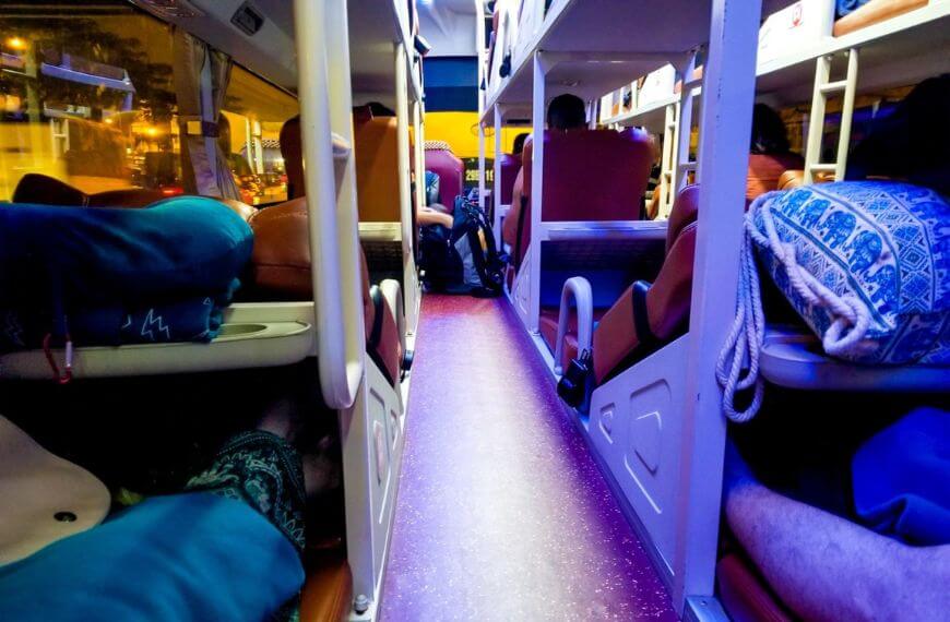 inside of a semi-sleeper bus with bunk beds on the backpackers route to southeast asia