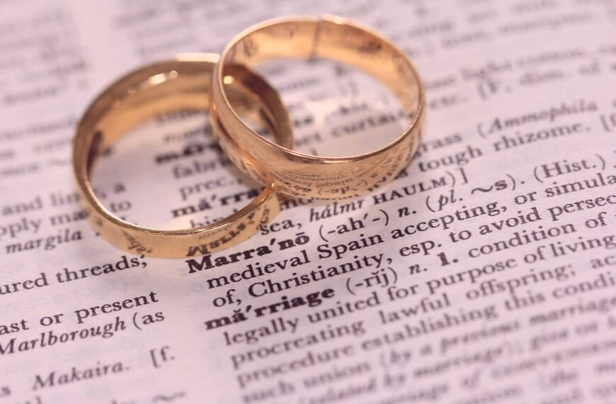 two wedding rings on a dictionary - an extended honeymoon is another great reason to take a grown-up gap year