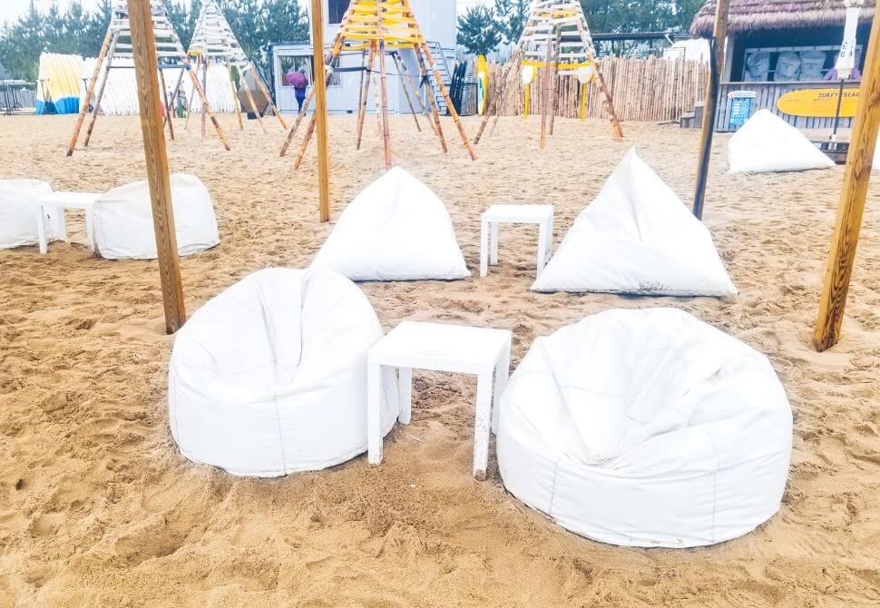 White beanbags and small tables located on Surfyy Beach in Korea