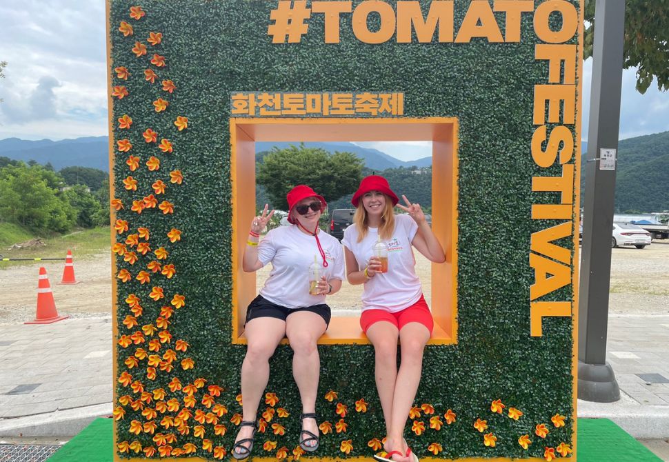 A photo zone with two friends posing at a fruit festival
